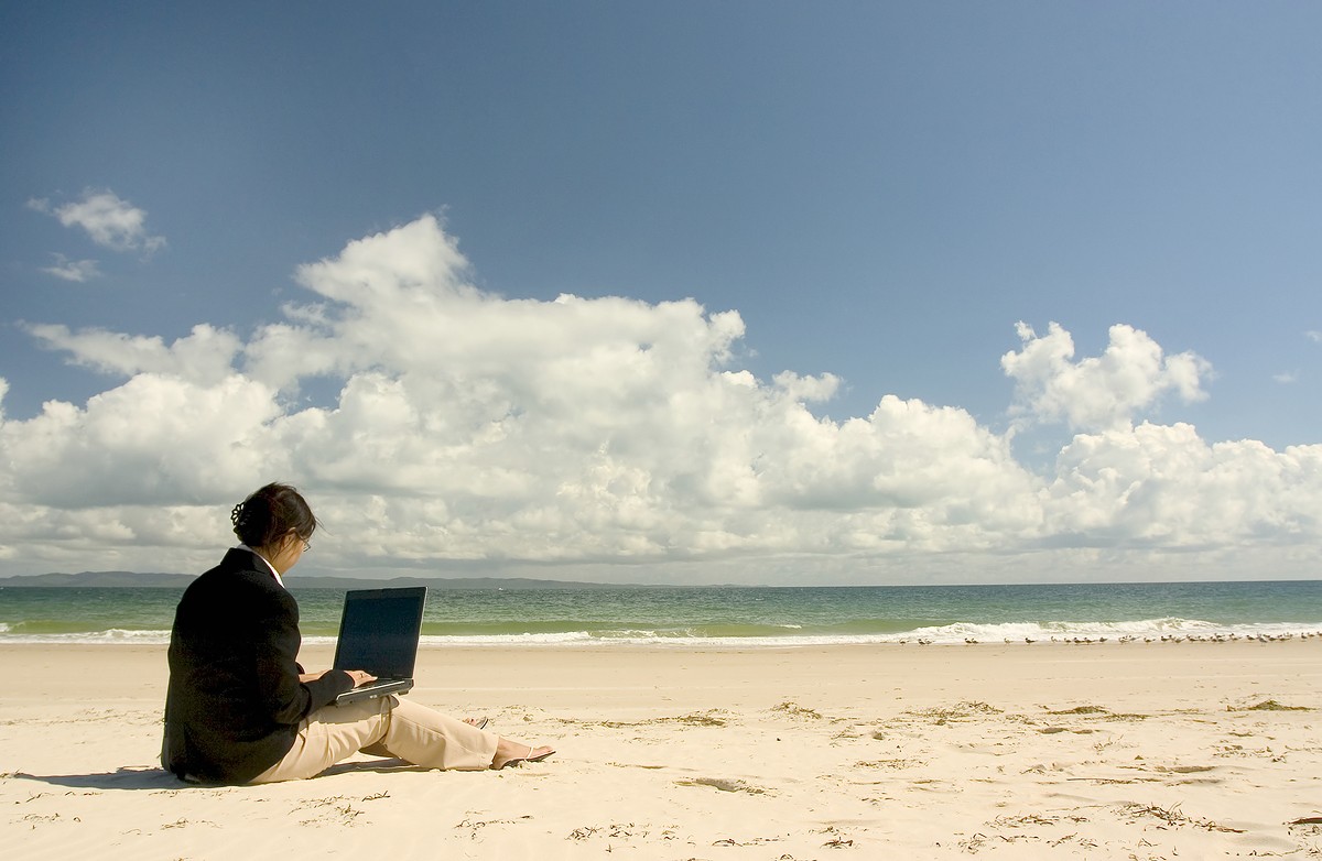 man with laptop on the beach